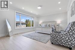 Spacious room featuring wood-finish flooring, a large multi-pane window, recessed lighting, and a decorative accent wall with geometric molding - 