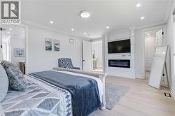 Light wood-finish flooring complements a built-in fireplace feature wall with integrated media space - 