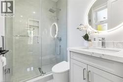 Modern bathroom featuring a glass-enclosed shower with a rainfall showerhead and built-in niche - 