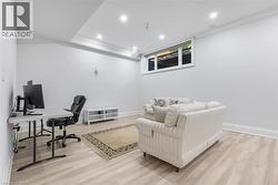 Finished interior space featuring light wood-finish flooring, white walls, and recessed lighting - 