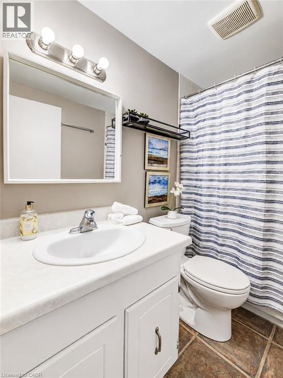 White vanity with an integrated sink, brushed nickel faucet, and a wall-mounted mirror - 4 Avalon Place Unit# 303, Kitchener, ON