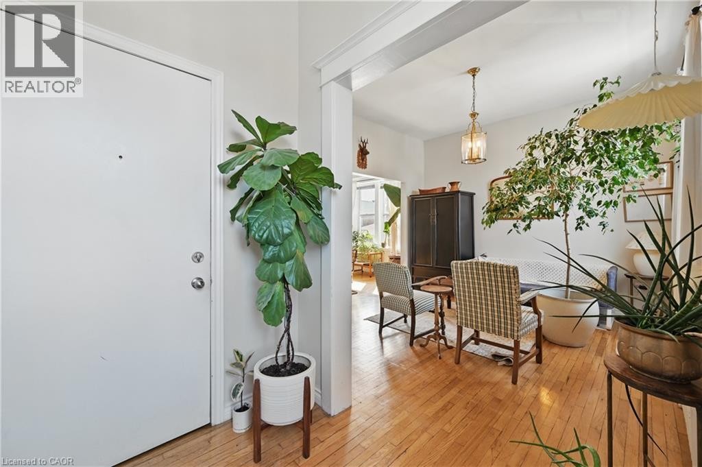 Hardwood flooring throughout, recessed archway, and a brass-finish pendant light fixture - 55 Barton Street W, Hamilton, ON
