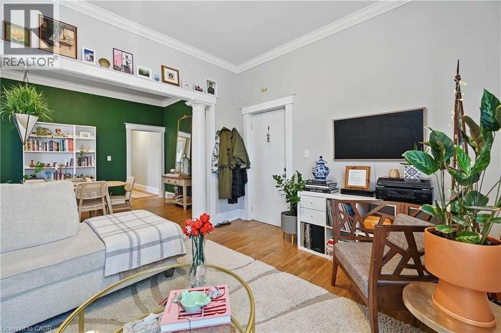 Hardwood-finish flooring, crown molding, white trim, and a built-in bookshelf - 55 Barton Street W, Hamilton, ON