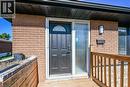 Brick exterior with a dark entry door featuring an arched decorative glass insert - 135 Nugent Drive, Hamilton, ON 