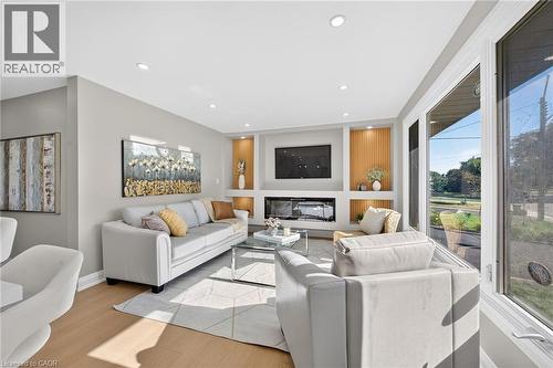 Recessed lighting, wood-finish flooring, large picture window, and a built-in media center with a fireplace and accent shelving - 135 Nugent Drive, Hamilton, ON 