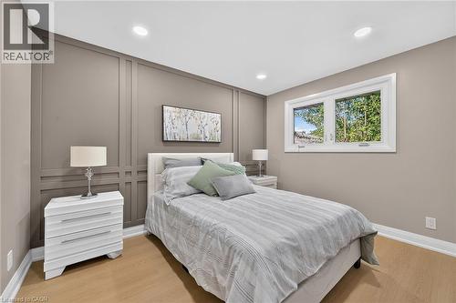 Recessed lighting, light wood-finish flooring, accent wall with decorative molding, and a white-framed window - 135 Nugent Drive, Hamilton, ON 