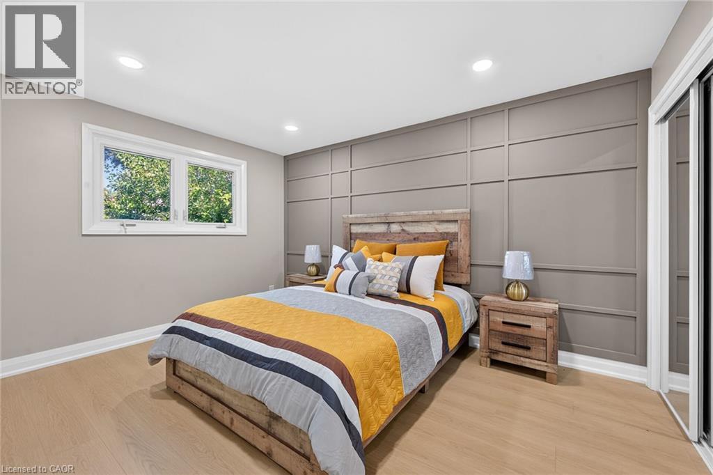 Accent wall with geometric paneling, recessed ceiling lighting, wood-finish flooring, and white trim molding - 135 Nugent Drive, Hamilton, ON