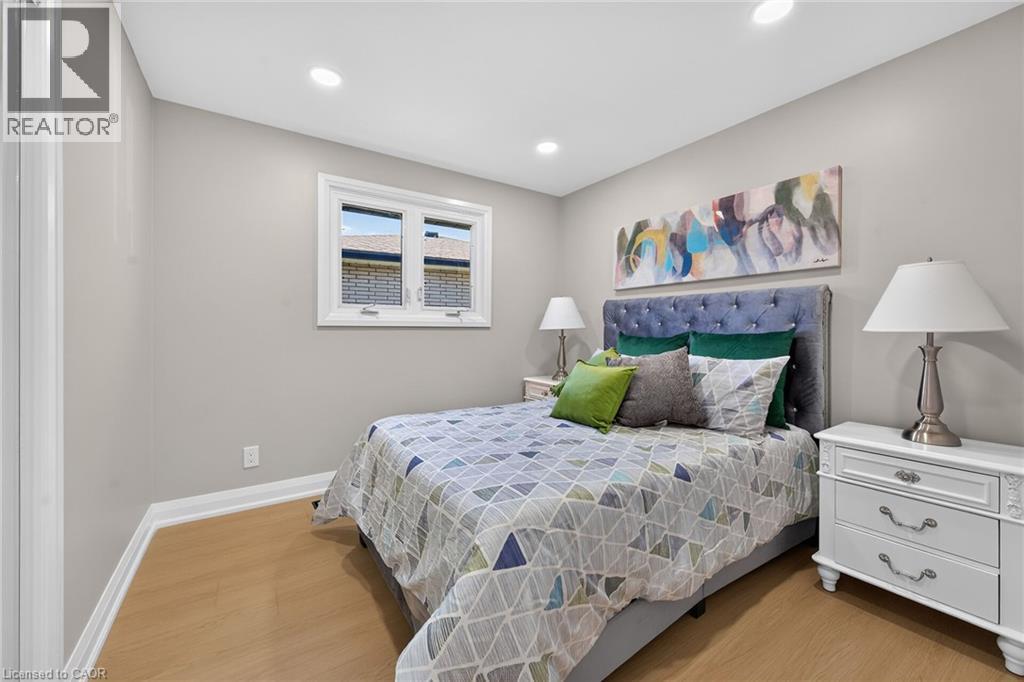 Recessed lighting, light-toned walls, wood-finish flooring, and a single window with white trim - 135 Nugent Drive, Hamilton, ON