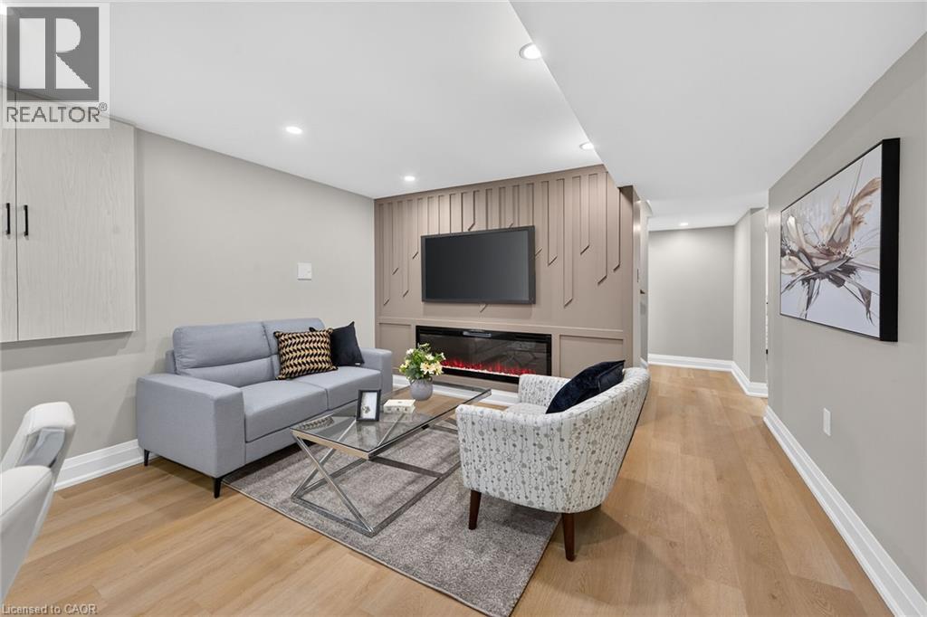 Recessed lighting, wood-finish flooring, built-in wall cabinetry, integrated electric fireplace, and decorative wall paneling - 135 Nugent Drive, Hamilton, ON