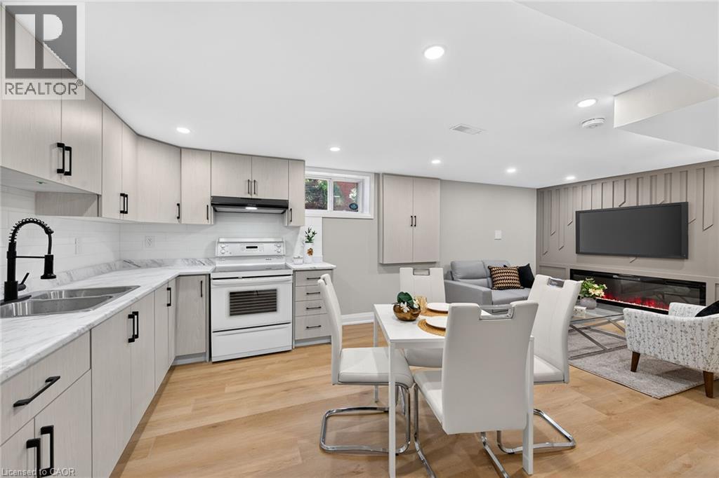 Full kitchen with light-toned cabinetry, white appliances, and a black gooseneck faucet - 135 Nugent Drive, Hamilton, ON