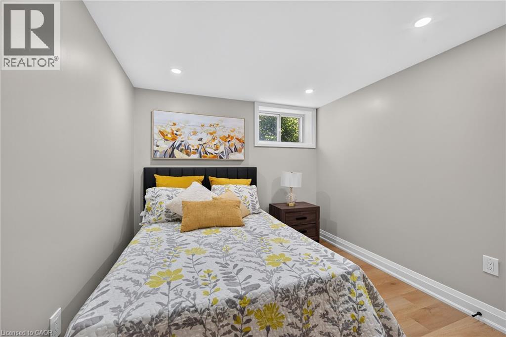 Recessed lighting, wood-finish flooring, and a window with white trim - 135 Nugent Drive, Hamilton, ON