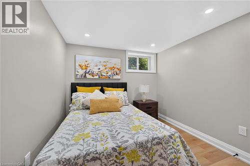 Recessed lighting, wood-finish flooring, and a window with white trim - 135 Nugent Drive, Hamilton, ON 