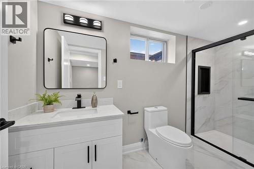 White vanity with a light-toned countertop, black framed mirror, and matte black fixtures - 135 Nugent Drive, Hamilton, ON 