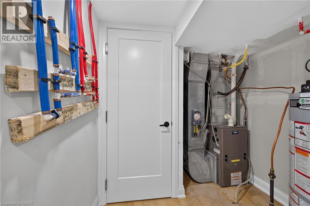 Utility area featuring a water heater, furnace, and visible plumbing distribution system - 135 Nugent Drive, Hamilton, ON