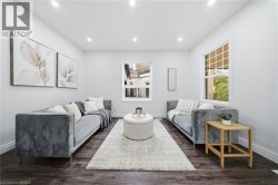 Recessed lighting illuminating the bright interior, wood-finish flooring, white trim, and a window with grid detailing - 