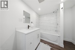 White vanity with a solid surface countertop, undermount sink, and matte black faucet - 