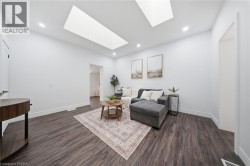 Recessed lighting, two skylights, and dark wood-finish flooring complement the white walls and trim - 