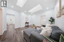 Recessed lighting, two skylights, wood-finish flooring, and white walls throughout - 