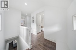 Bright hallway featuring wood-finish flooring, white walls, and recessed lighting - 