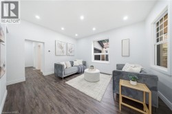 Recessed ceiling lighting, wood-finish flooring, white wall paint, multiple windows, and a doorway - 