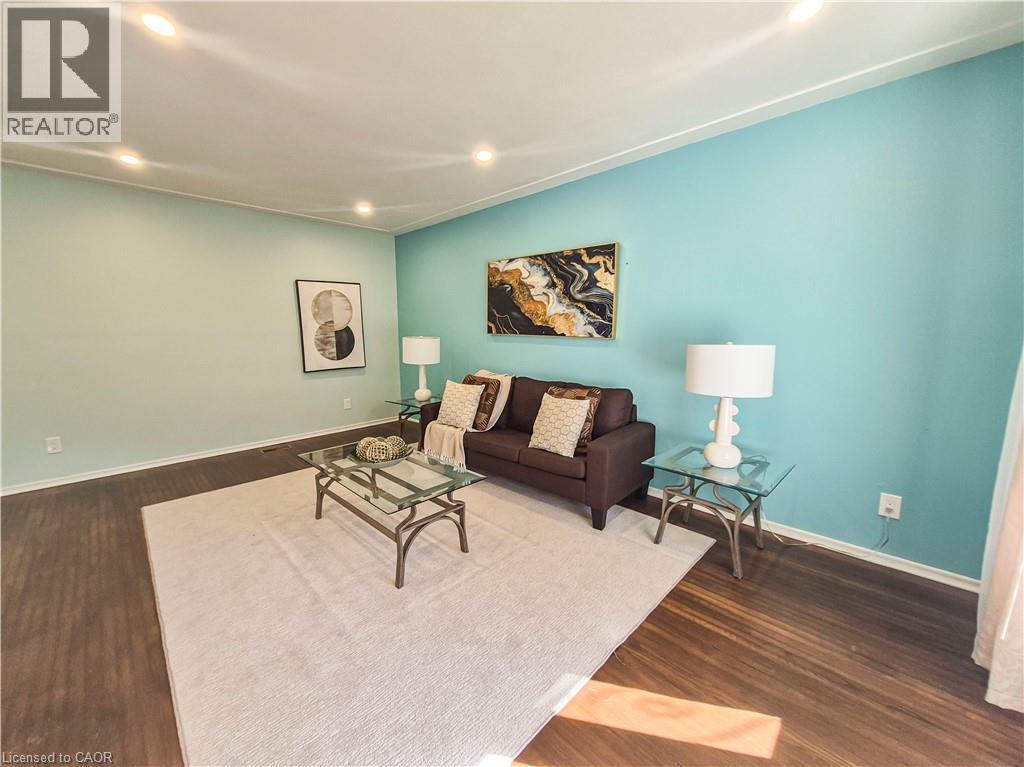 Recessed lighting illuminates the room, featuring wood-finish flooring and crown molding - 11 Duncairn Avenue, Kitchener, ON