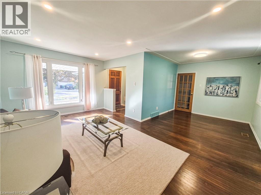 Hardwood flooring, recessed ceiling lighting, a large picture window, and a wood-finish interior door with glass panels - 11 Duncairn Avenue, Kitchener, ON