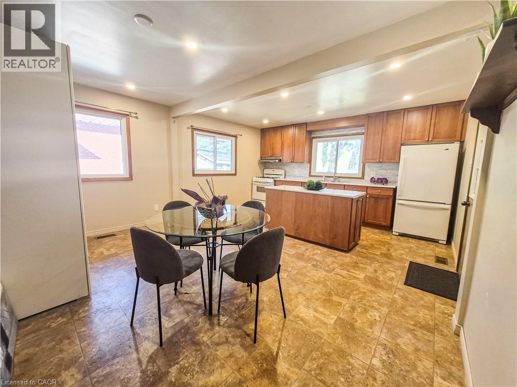 Kitchen featuring wood-finish cabinetry, a large kitchen island, tiled flooring, and recessed lighting - 11 Duncairn Avenue, Kitchener, ON