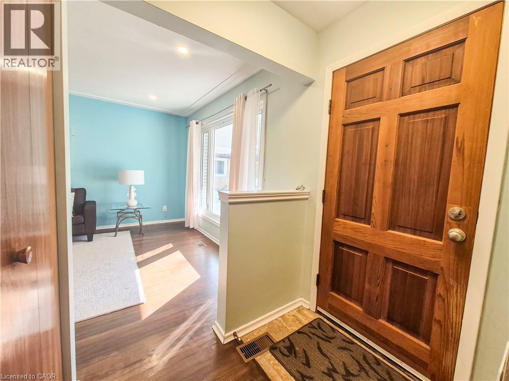 Paneled wood entry door, wood-finish flooring, recessed lighting, cased opening, and large window - 11 Duncairn Avenue, Kitchener, ON
