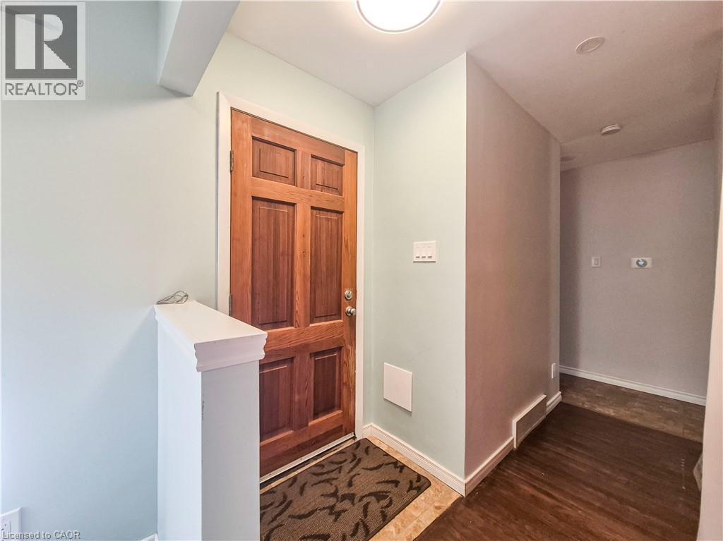 Paneled wood-finish entry door, ceiling-mounted light fixture, and wood-finish flooring - 11 Duncairn Avenue, Kitchener, ON