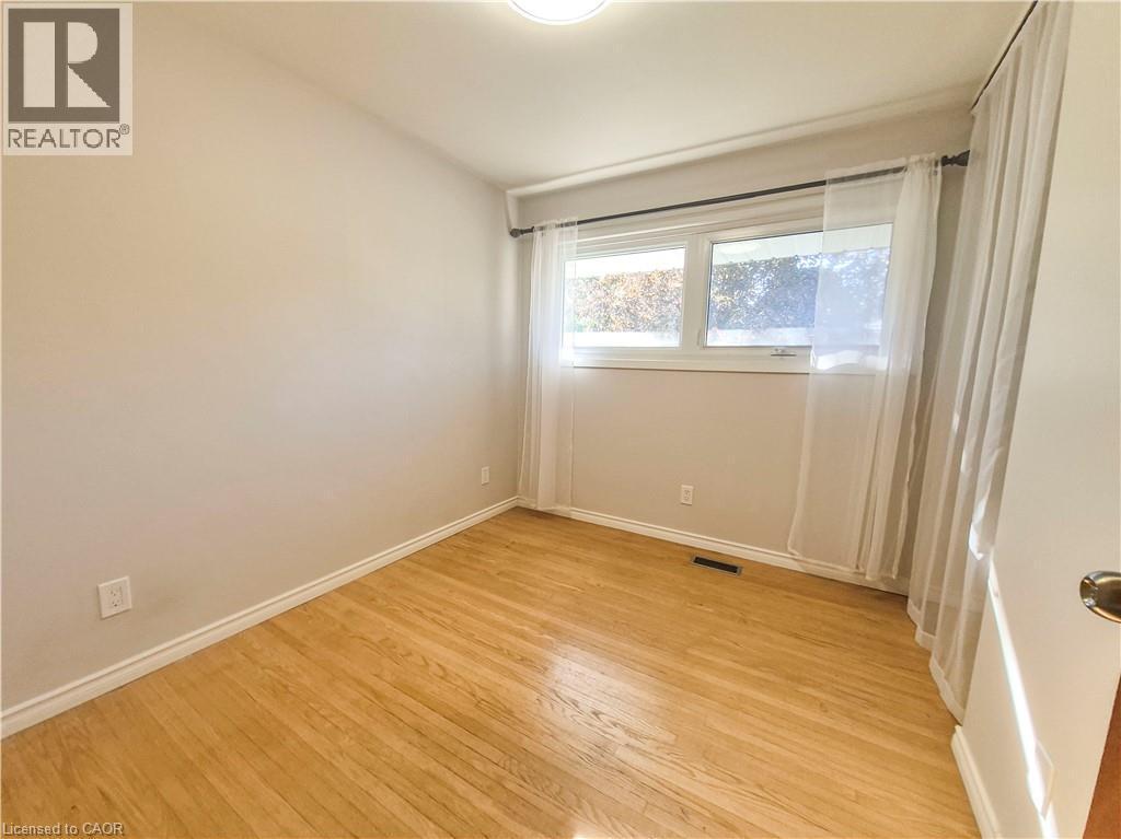 Hardwood flooring, neutral wall tones, window with natural light, and ceiling-mounted light fixture - 11 Duncairn Avenue, Kitchener, ON