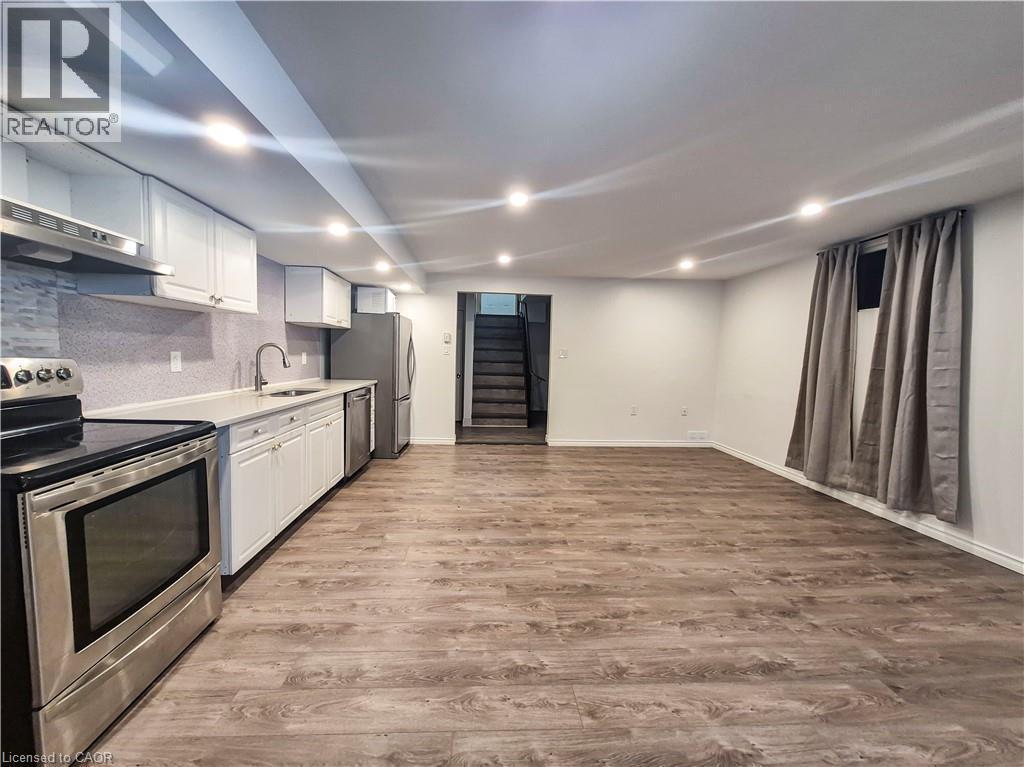 Open-concept living space with wood-finish flooring, recessed lighting, and stainless steel appliances - 11 Duncairn Avenue, Kitchener, ON