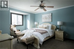 Ceiling fan with integrated lighting, a window with dark trim, light blue wall paint, and crown molding - 