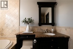 Built-in black vanity with an integrated sink, polished chrome faucet, and a stone countertop - 