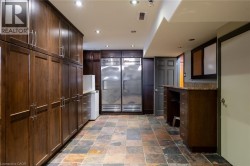 Extensive wood-finish cabinetry, stainless steel appliances, stone-finish flooring, recessed lighting, and a built-in desk area - 