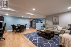 Wood-finish flooring throughout, recessed lighting, and a partial wall separating spaces - 