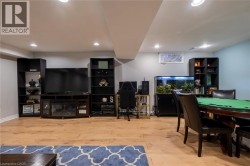Recessed lighting throughout, light wood-finish flooring, built-in entertainment center with an electric fireplace, and a window with natural light - 