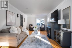 Recessed lighting, crown molding, wood-finish flooring, a built-in electric fireplace, and a glass-paneled entry door - 