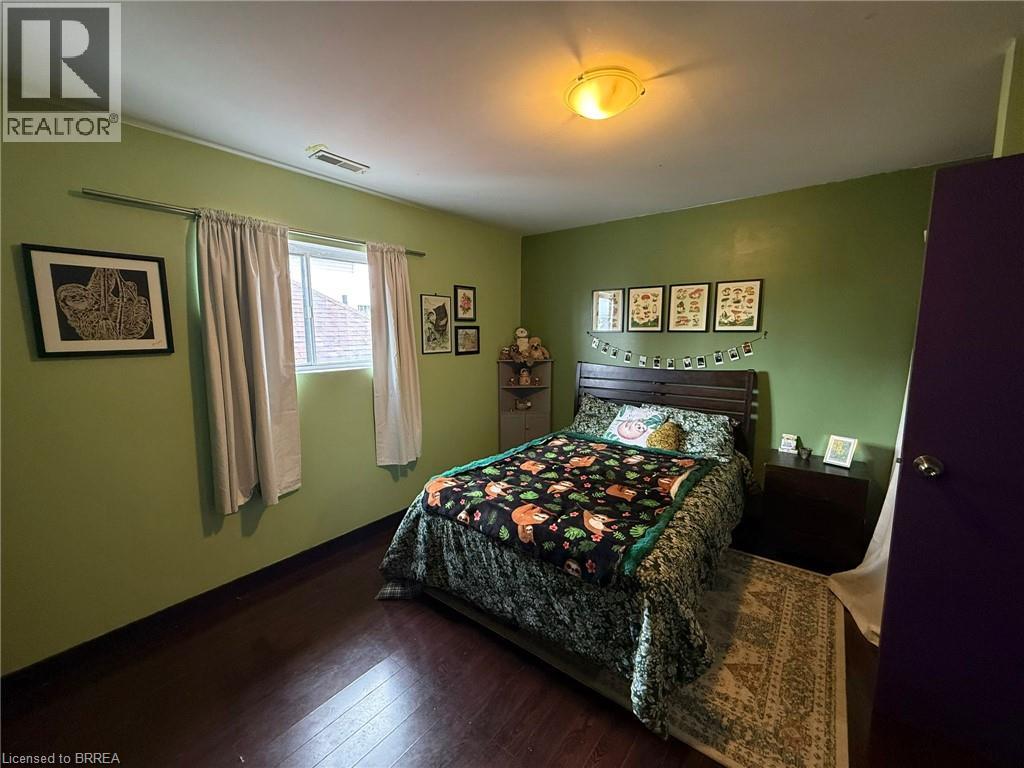 Wood-finish flooring with a window offering natural light, complemented by an overhead flush-mount light fixture - 12 Bridgeport Road E Unit# 18, Waterloo, ON