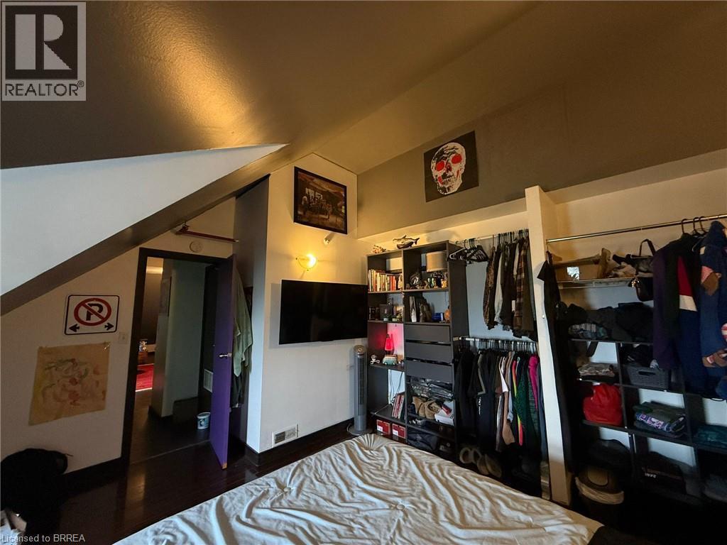 Wood-finish flooring with a multi-level ceiling design and an open closet system - 12 Bridgeport Road E Unit# 18, Waterloo, ON