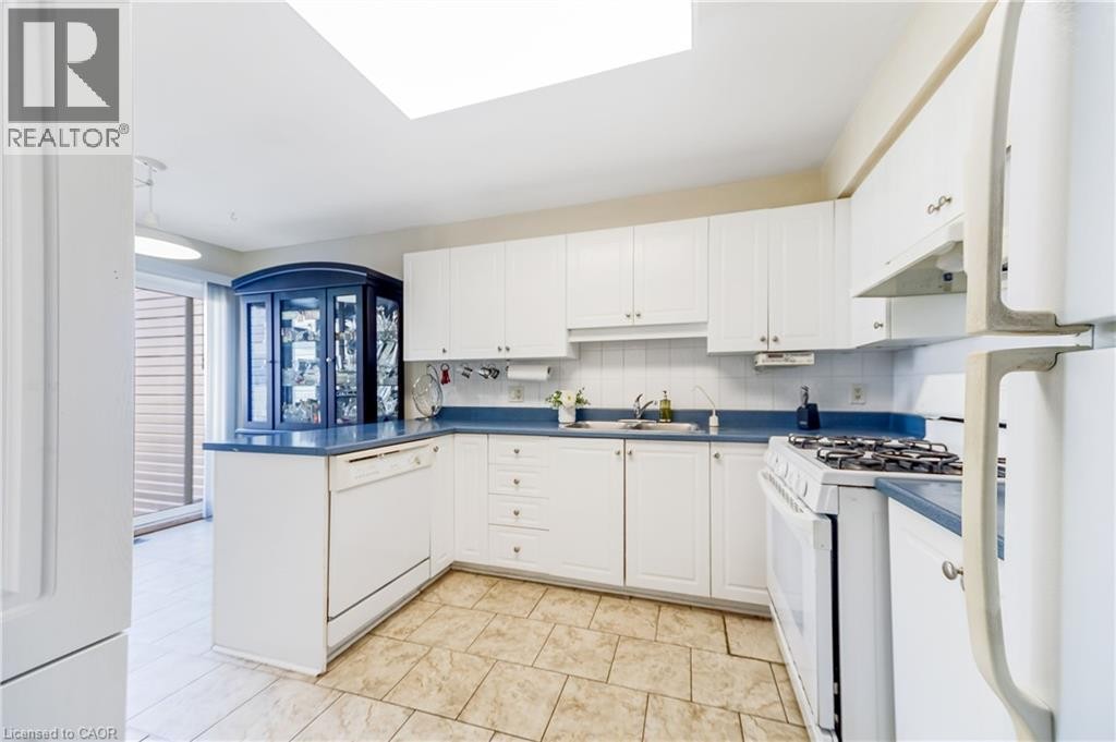 Kitchen featuring white cabinetry, blue countertops, tile flooring, a built-in dishwasher, and a gas range - 82 Milner Downs Crescent, Ottawa, ON