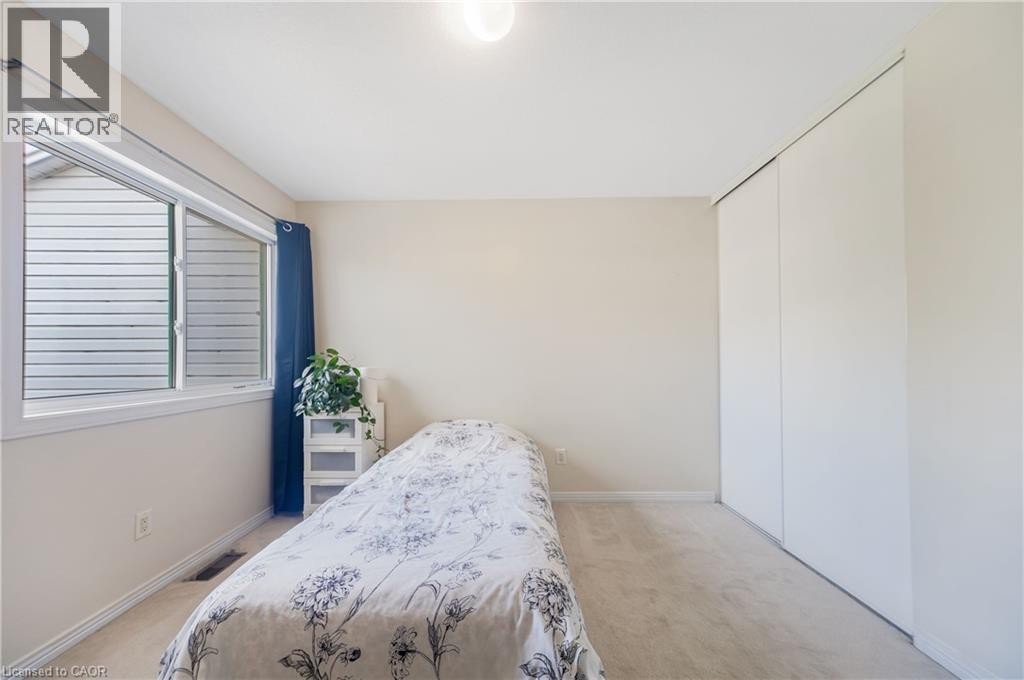 Bright room featuring a large window, neutral carpeting, and a built-in closet with sliding doors - 82 Milner Downs Crescent, Ottawa, ON