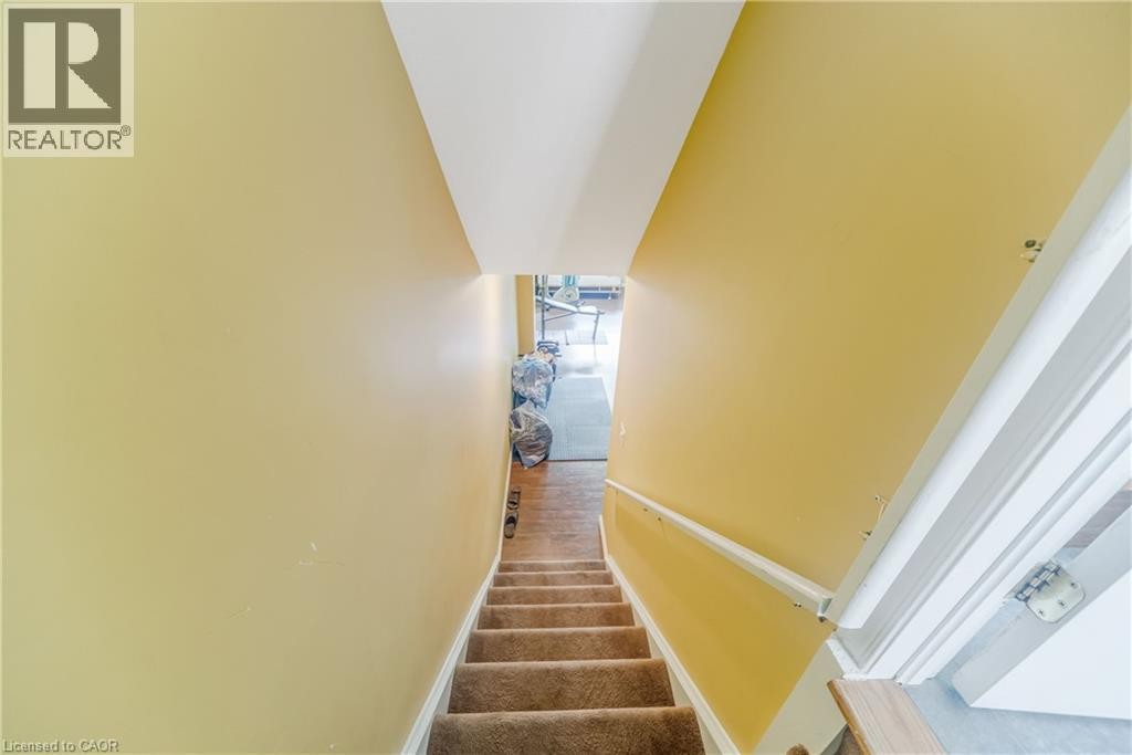 Carpeted staircase with a white handrail and yellow walls - 82 Milner Downs Crescent, Ottawa, ON