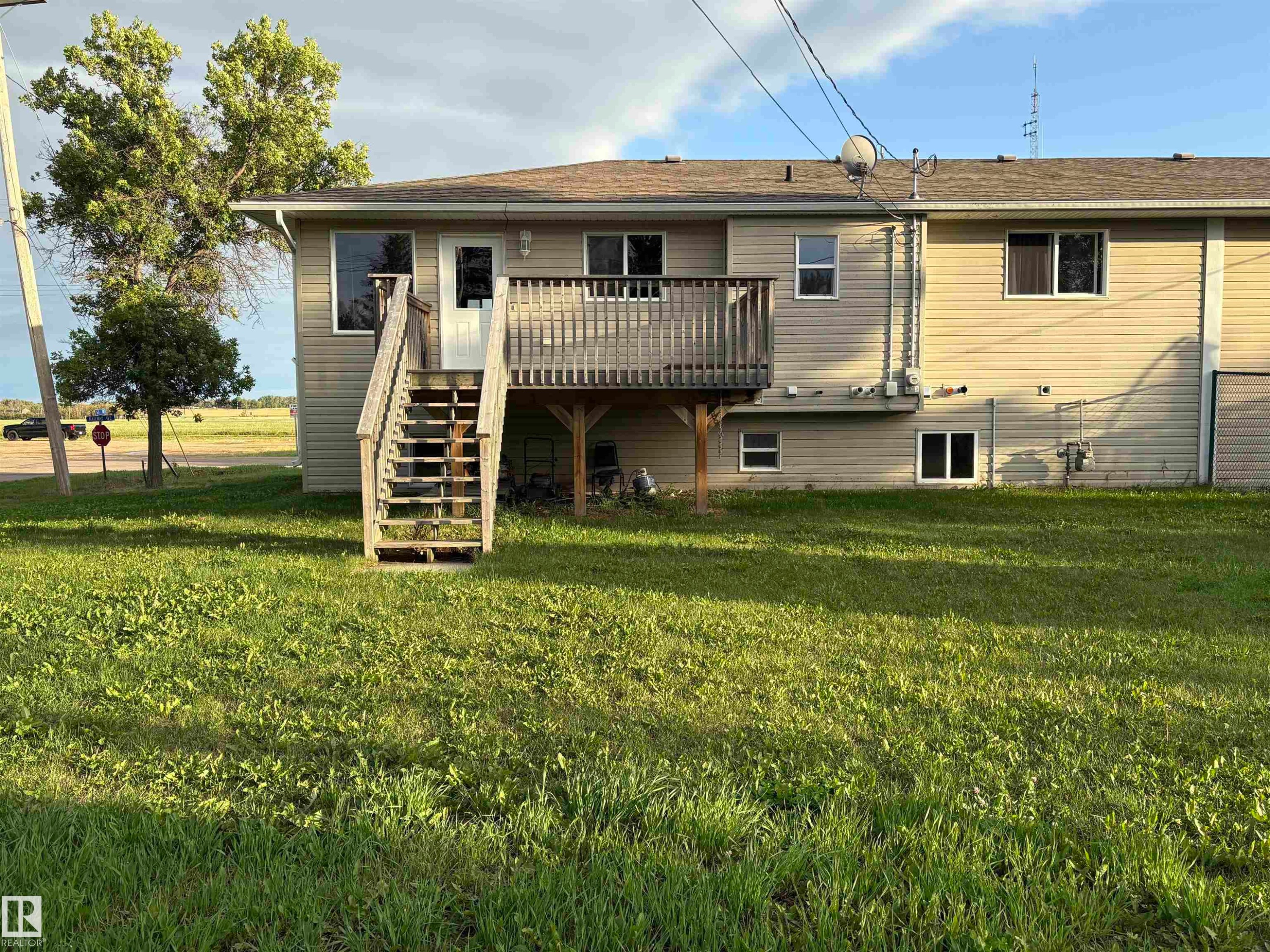 Back of house featuring a wooden deck, stairway. - 5302 Railway Avenue, Elk Point, AB - Outdoor With Deck Patio Veranda