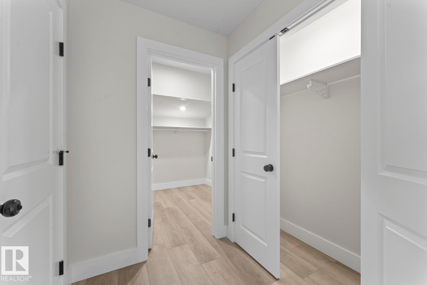 The property features light-colored flooring, white interior doors with dark hardware, and a closet with shelving - 807 Schooner Drive, Cold Lake, AB - Indoor Photo Showing Other Room
