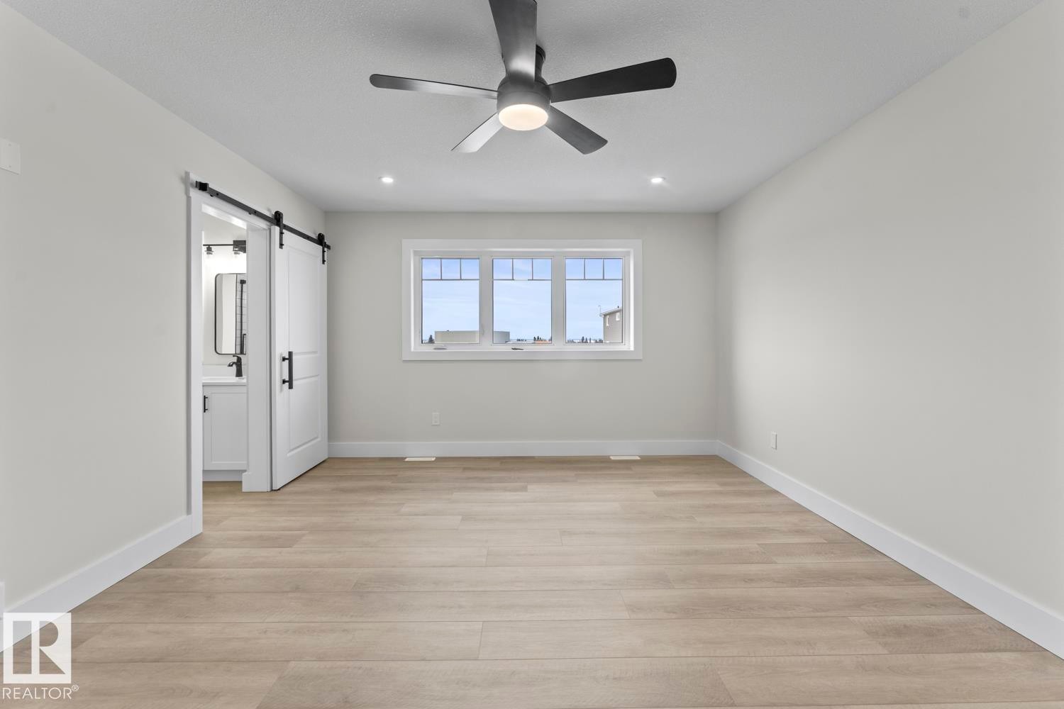 This room features light-colored flooring, a window providing natural light, and a ceiling fan with integrated lighting - 807 Schooner Drive, Cold Lake, AB - Indoor Photo Showing Other Room