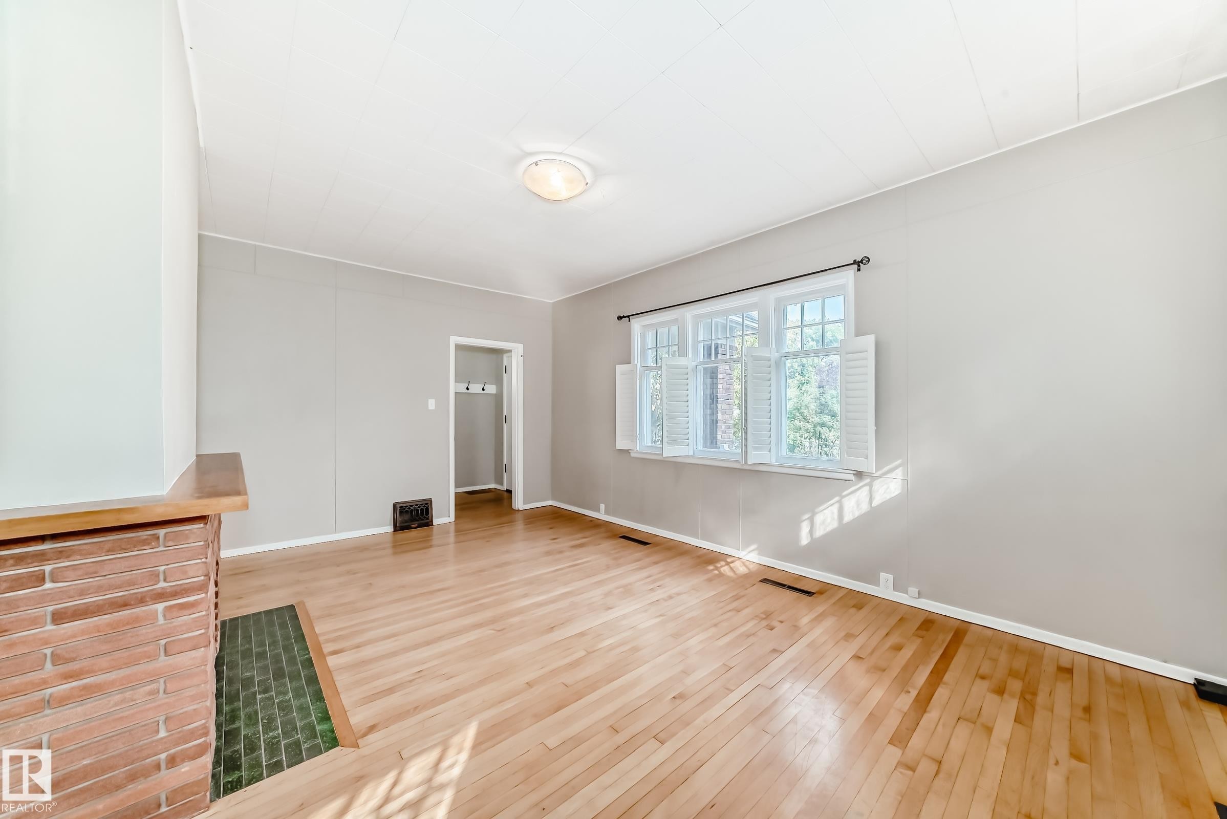 Unfurnished living room featuring light wood-style floors and baseboards - 12605 107 Avenue, Edmonton, AB - Indoor Photo Showing Other Room