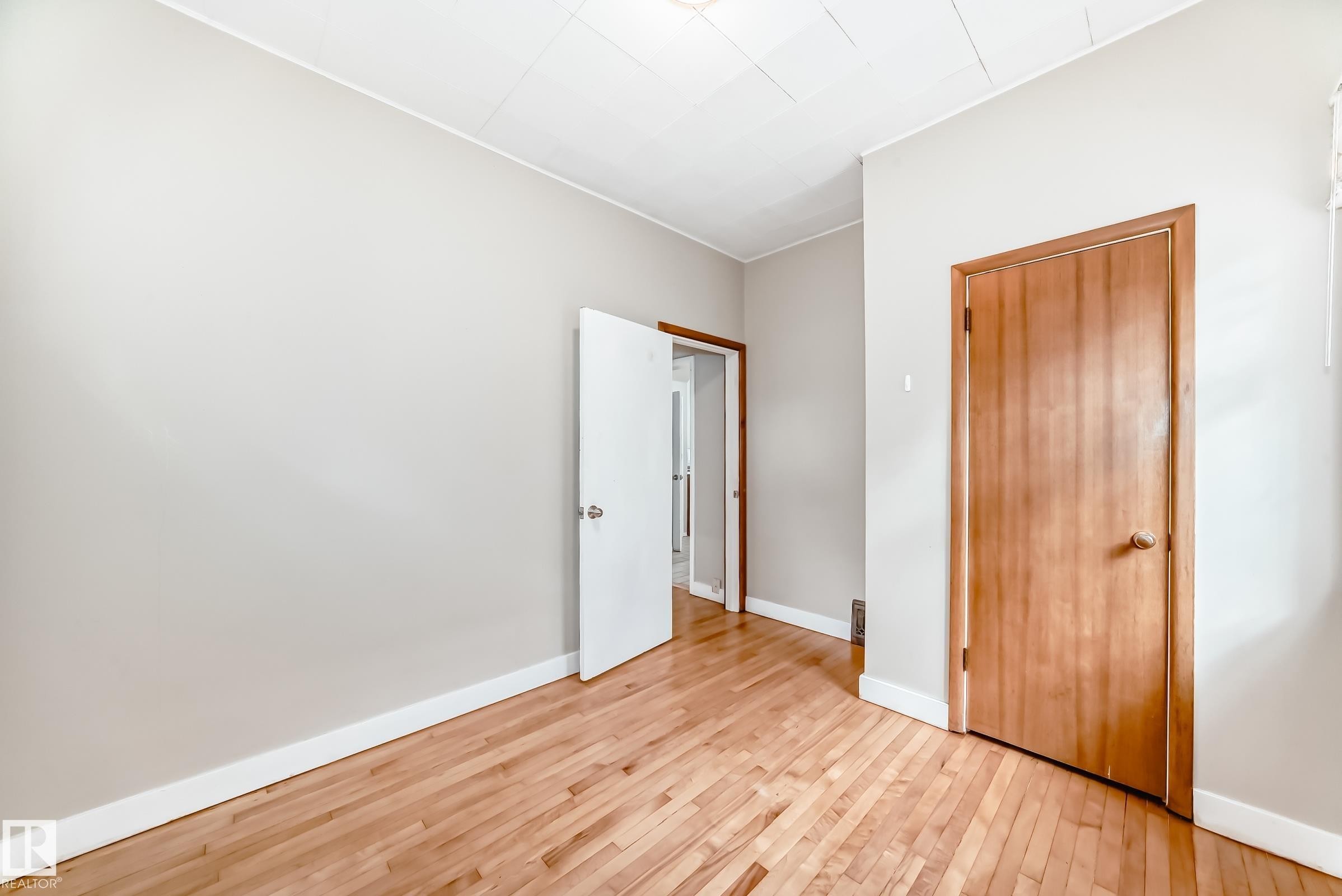 Unfurnished bedroom with hardwood / wood-style flooring and a closet - 12605 107 Avenue, Edmonton, AB - Indoor Photo Showing Other Room
