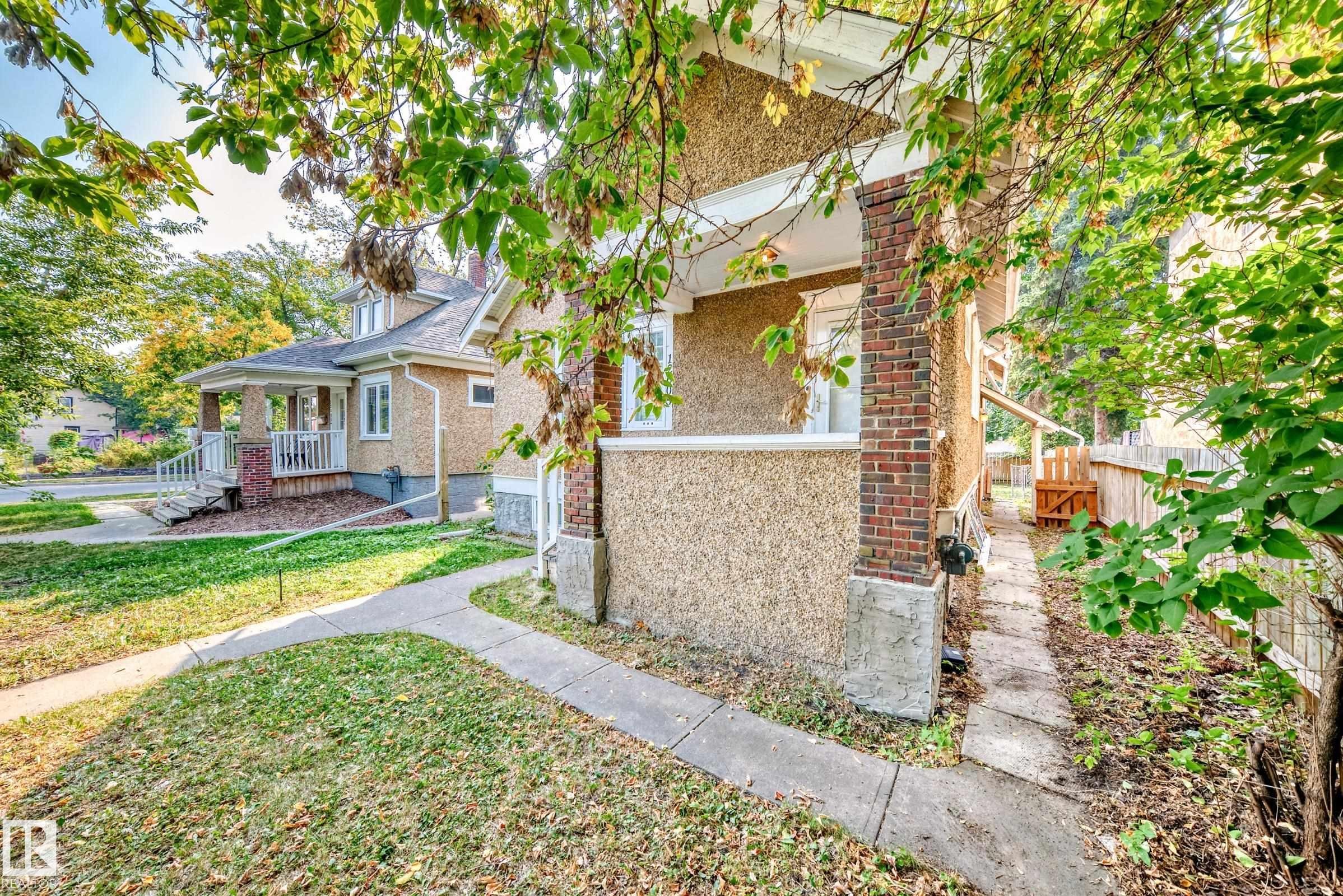 View of home's exterior with a porch, brick siding, and a yard - 12605 107 Avenue, Edmonton, AB - Outdoor