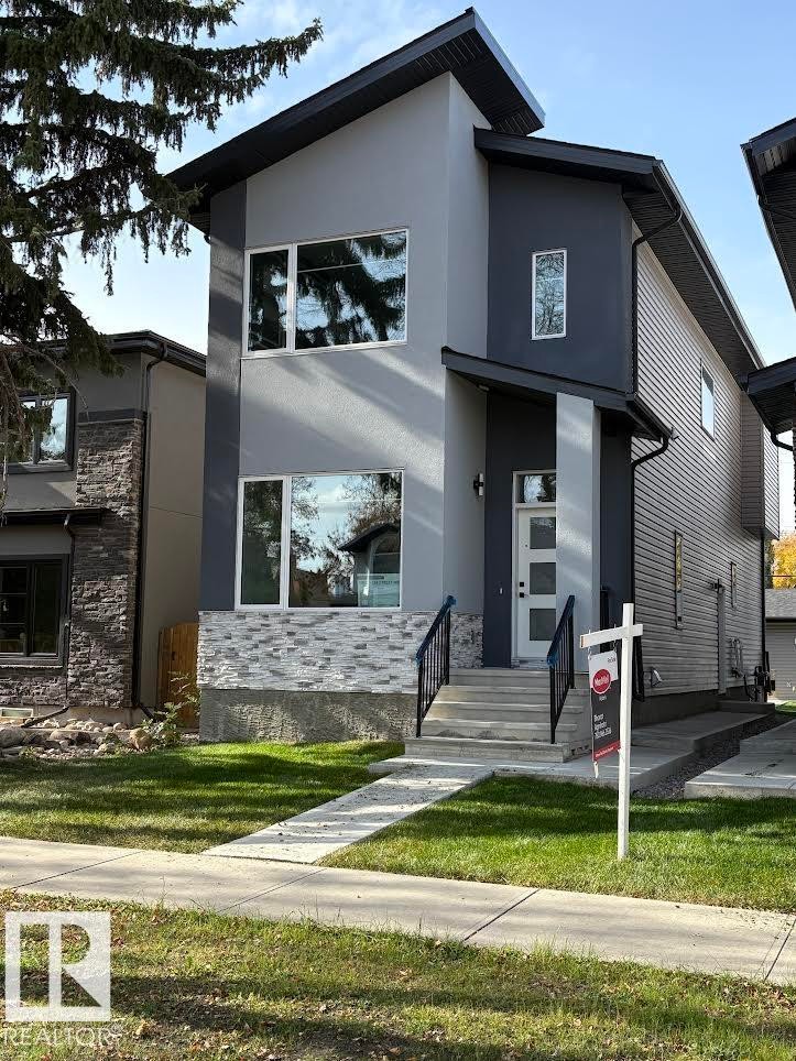 Contemporary house featuring stucco siding, a front yard, and stone siding - 11032 128 Street, Edmonton, AB - Outdoor