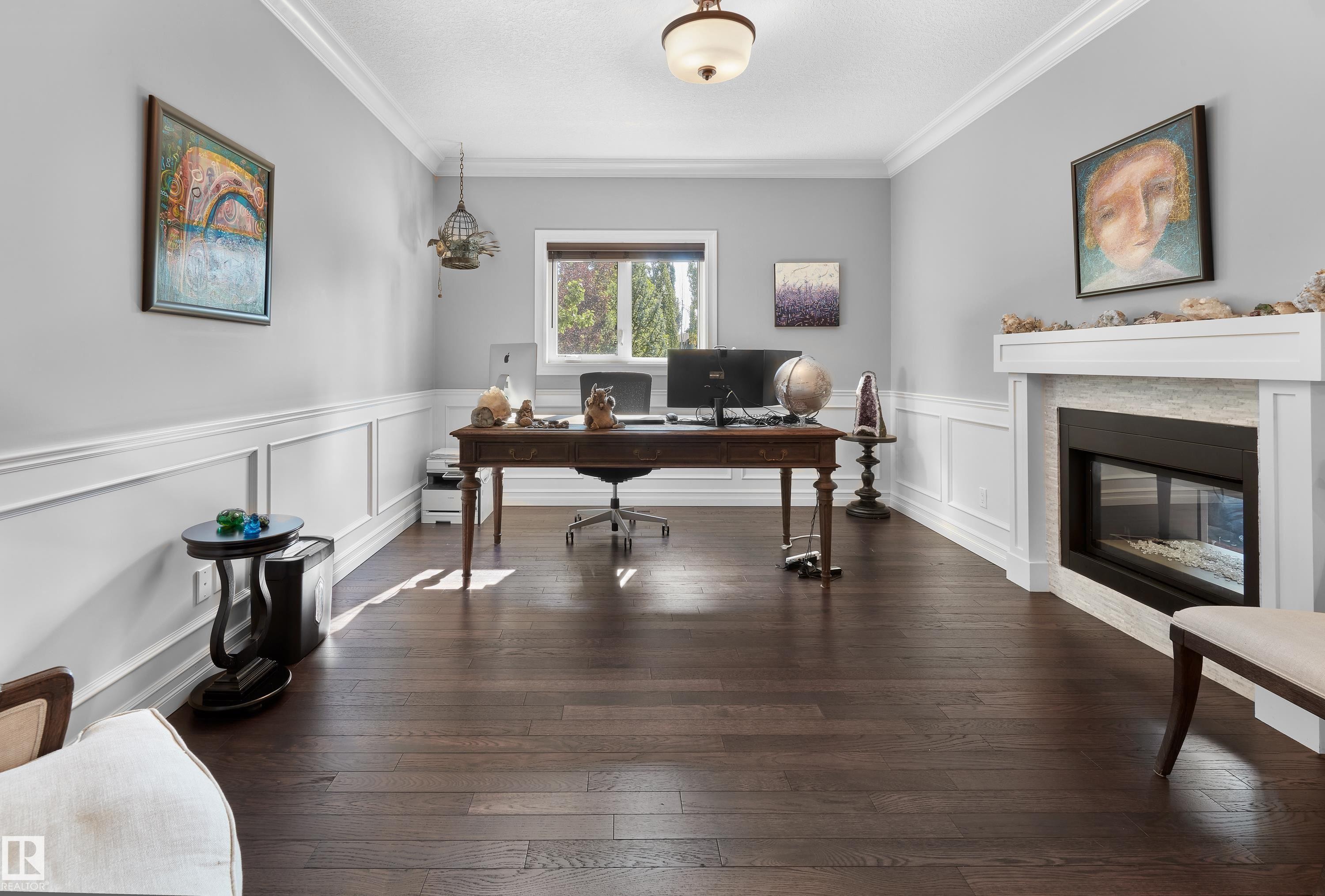 Home office with crown molding, hardwood / wood-style flooring, a glass covered fireplace, and a decorative wall - 4111 Westcliff Heath Heath, Edmonton, AB - Indoor Photo Showing Office With Fireplace